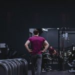 Man in a gym with fitness equipment, highlighting a healthy lifestyle.